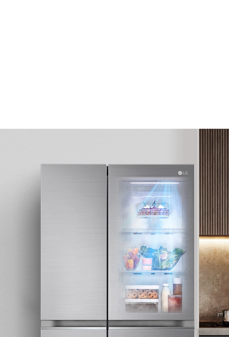 The front view of an InstaView refrigerator with the light on inside. The contents of the refrigerator can be seen through the InstaView door. Blue rays of light shine down over the contents from the DoorCooling function.