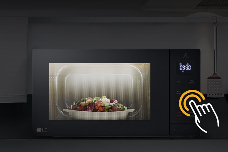 Microwave is placed within a darkened kitchen environment, while the internal LED lights in the microwave illuminate the food inside.
