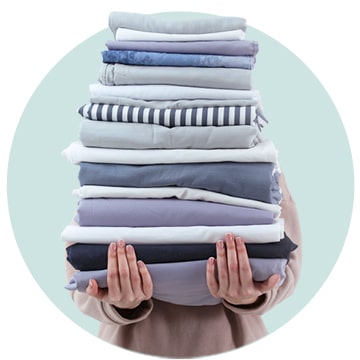 A person is holding a pile of clothes.