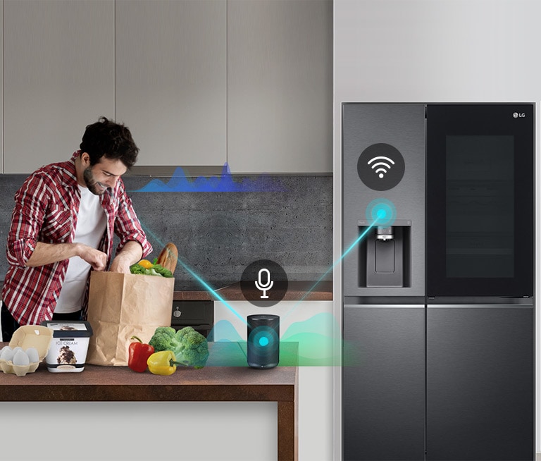 Un hombre se encuentra en una cocina descargando productos de una bolsa de supermercado y habla, como lo muestran las barras de volumen que se mueven hacia arriba y hacia abajo cerca de él, al altavoz de IA en el mostrador diciéndole que "encienda el congelamiento rápido". Aparece una línea que va desde el hombre hasta el altavoz de IA que tiene un icono de micrófono encima. Luego, aparecen barras de volumen cerca del altavoz AI y aparece una línea desde el altavoz AI hasta el refrigerador que tiene un icono de Wifi encima.