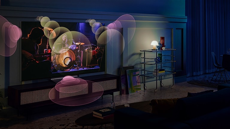 Personas sentadas en un sofá viendo un concierto con burbujas que representan sonido envolvente a su alrededor.