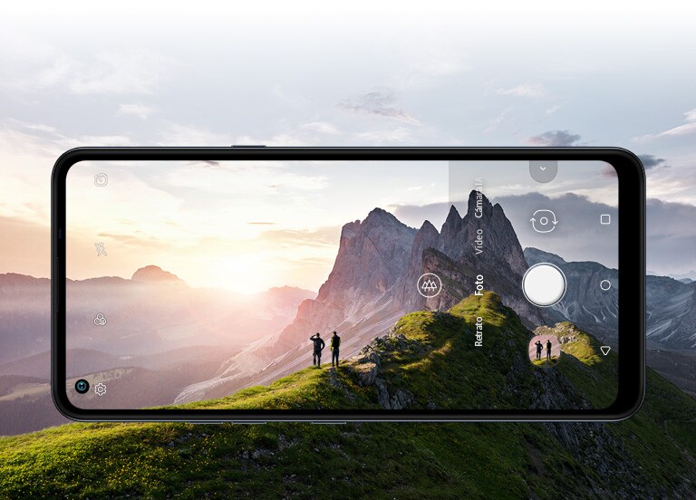 Teléfono inteligente fotografiando a dos personas que miran el amanecer en la montaña
