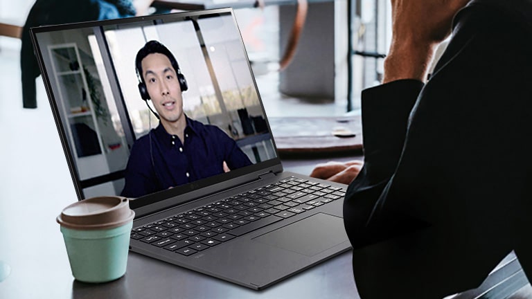 Muestra una escena en la que un hombre tiene una videoconferencia en el café.