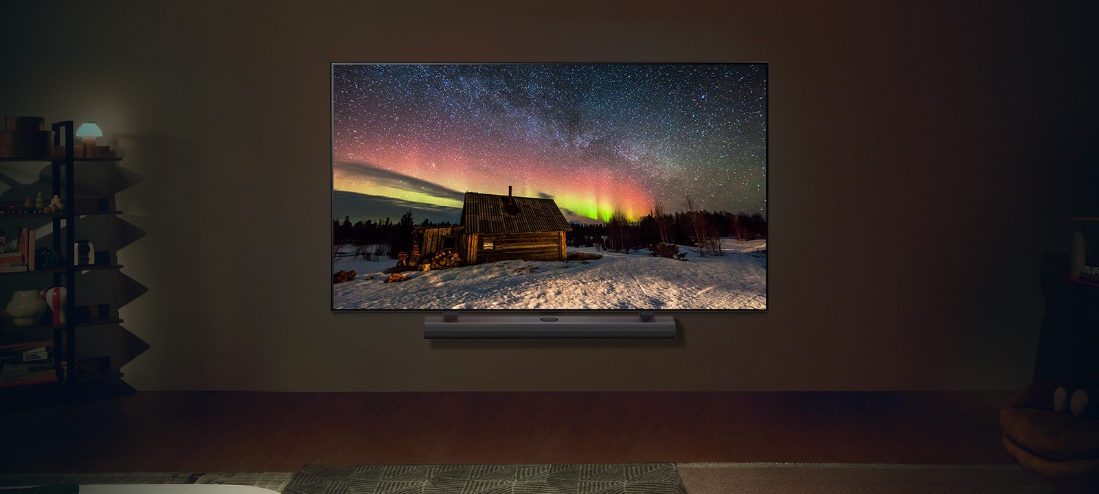 TV LG y barra de sonido LG en un moderno salón por la noche. La imagen en pantalla de la aurora boreal se muestra con los niveles de brillo ideales.