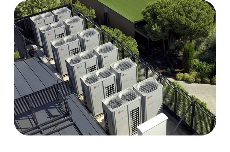 LG HVAC solutions are arranged vertically within the confines of barbed wire, while lush green trees and grass flourish on the right side outside the perimeter.