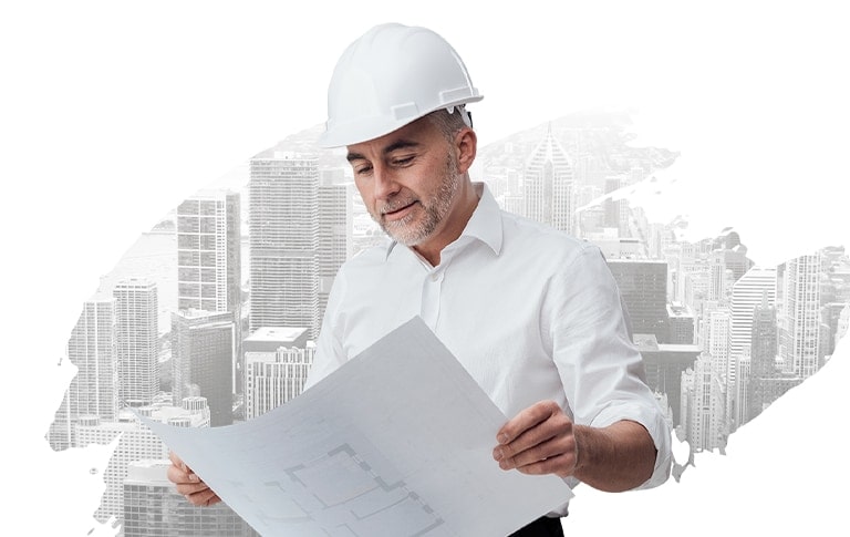 A man dressed in a white shirt and a hard hat is observed studying a blueprint, with gray buildings visible in the background.