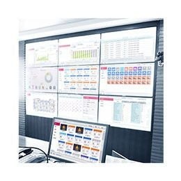 A series of screens displaying charts and diagrams are projected on a larger retangular screen while a computer monitor is placed at the front. 