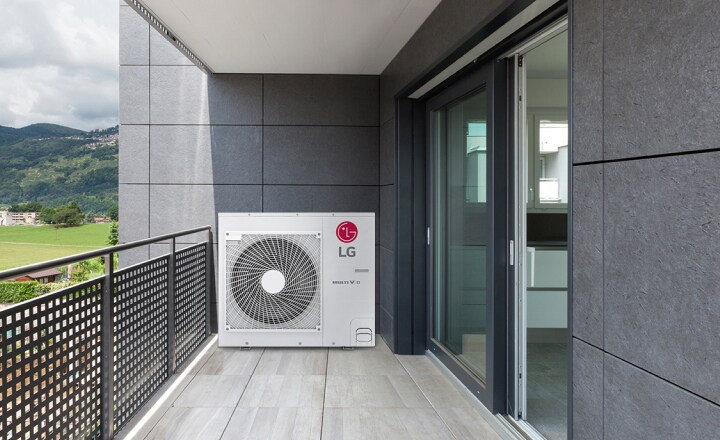 A gray tiled balcony with a checkered fence showcases a central LG Multi V S outdoor unit. Mountains and green fields are visible on the left.