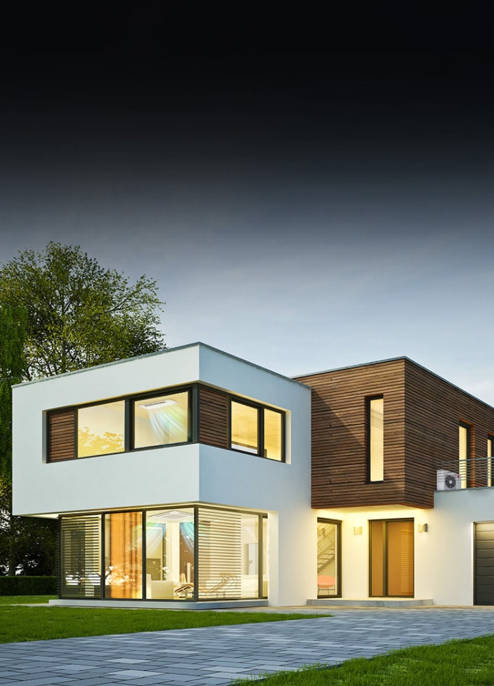 A house in white and wood tones. Both staircases feature ceiling-mounted air conditioning units with visible airflow. A front driveway with grass.	