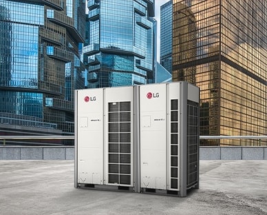 Two LG MULTI V i units stand side by side on a rooftop, front-facing view, against a backdrop of towering skyscrapers cloaked in the glass.