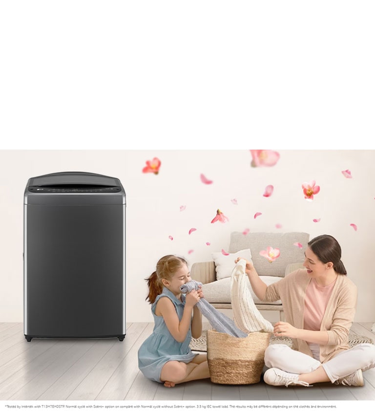 The 'scent' button on the LG washing machine is emphasized, a mother and daughter sit on the floor enjoying the smell of a towel that just came out of the washing machine that sits next to them. Petals are flying around them.