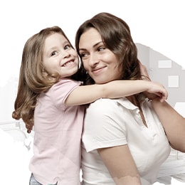 A mother and her daughter are hugging each other, wearing big smiles on their faces.