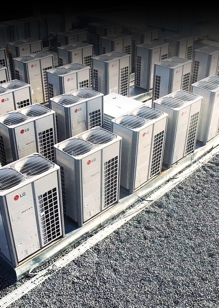 Bird-eye view of a series of LG Multi V i units, right half covered by checkered ventilation ducts, lined up on the building roof.