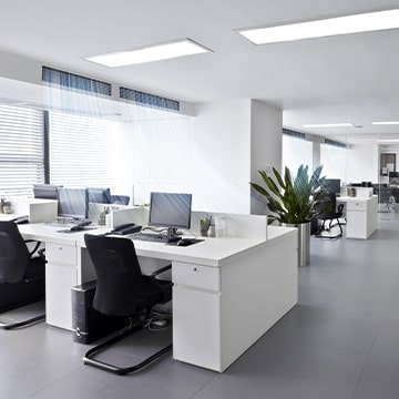 Contemporary open-plan workspace with sleek, minimalistic furniture, suggesting a professional and efficient environment.