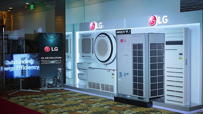 The LG Multi V i unit is positioned on the right, with two LG logos placed above it. The standing signboard displays the inscription 'LG Air Solution Product Launch & Appreciation Night' on the left side. In the center of whole image, the text 'LG PH Celebrates Success With Launch of the Energy Efficient Multi V i With Cutting-Edge AI Engine' is prominently displayed