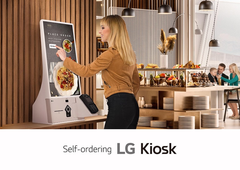 A woman is ordering food at a kiosk in a family restaurant.