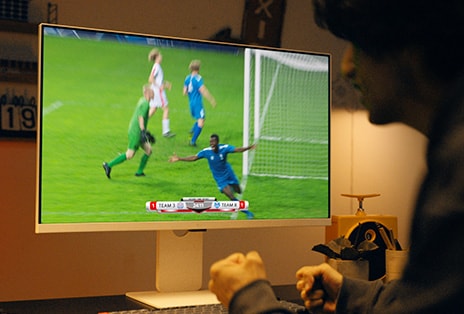 A young man enjoying sports in his room on the LG MyView Smart Monitor without a PC.