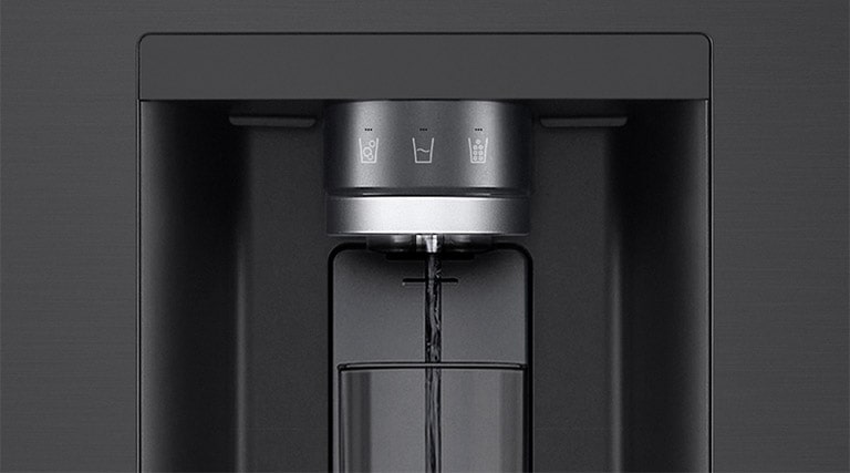 A video starts zoomed in on the water dispenser. The exterior of the refrigerator goes clear and now the interior of the door and mechanical parts of the dispenser nozzle can be seen. The video zooms in further to show the water droplets as they fall through the UVnano part of the nozzle which reduces the bacteria. The view zooms back out to see the exterior of the refrigerator again as water is being dispensed into a glass.