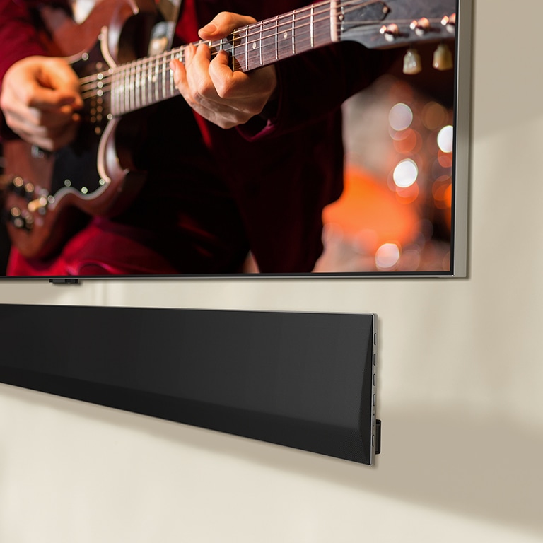 An angled perspective of the bottom of an LG OLED TV and LG Soundbar.
