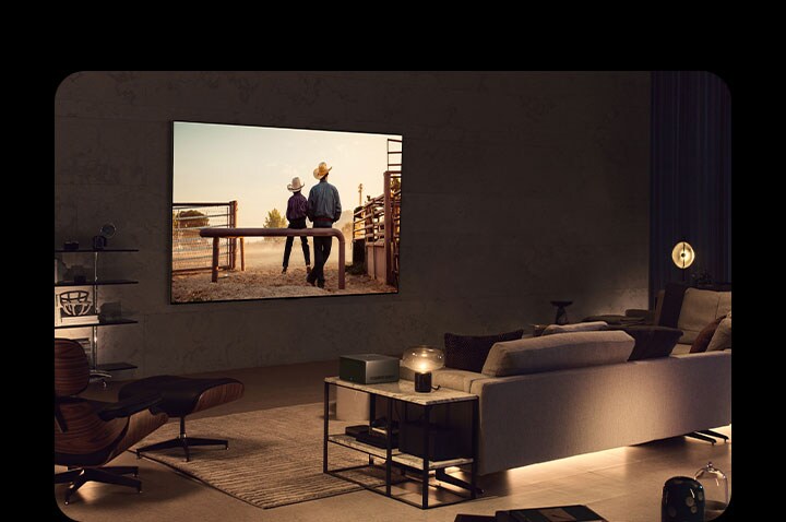 Wieczorem na LG OLED TV zawieszonym na ścianie wyświetlany jest western. Wokół smart TV nie ma żadnych kabli. Moduł Wireless Connect Box stoi schludnie na stoliku z boku. Obraz przesuwa się, ukazując inny salon z malowniczym widokiem samochodu na autostradzie wyświetlanym na ekranie LG OLED TV. Smart TV stoi na stojaku podłogowym, a wokół niego nie widać żadnych kabli. Moduł Wireless Connect Box stoi schludnie na stoliku z boku.