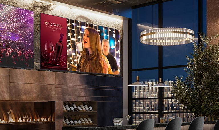 Dwa wyświetlacze są zainstalowane w luksusowej winiarni. Na jednym wyświetlona jest scena koncertowa, a na drugim dwa obrazy na jednym ekranie, które ukazują reklamę czerwonego wina oraz śpiewaczkę.