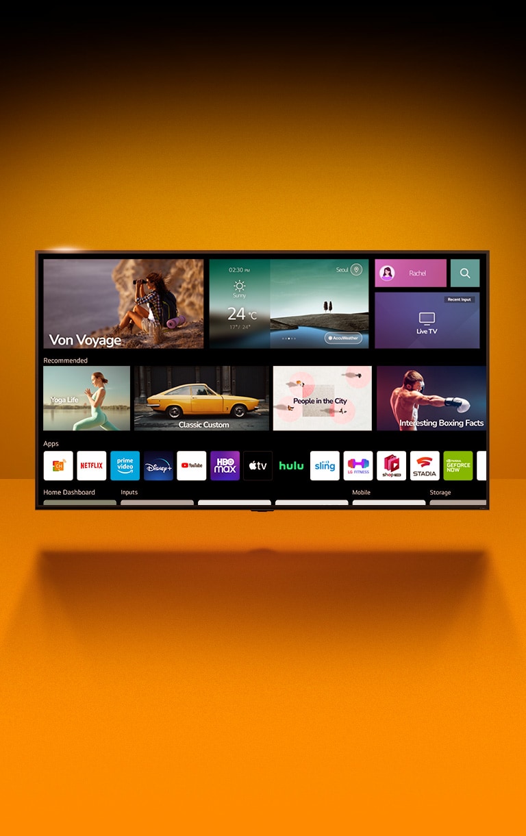 Telewizor stoi naprzeciw pomarańczowej ściany. Wyświetlony jest ekran główny z wyróżnioną listą aplikacji.