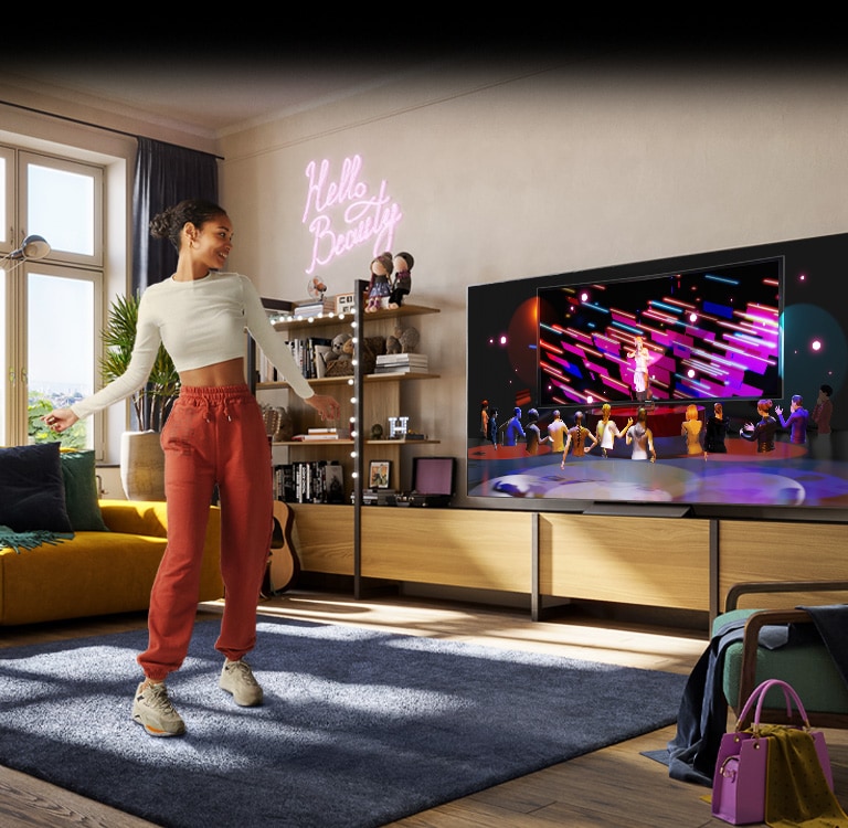 Kobieta tańczy w pokoju podczas oglądania koncertu w Metaverse „Sansar” na telewizorze.