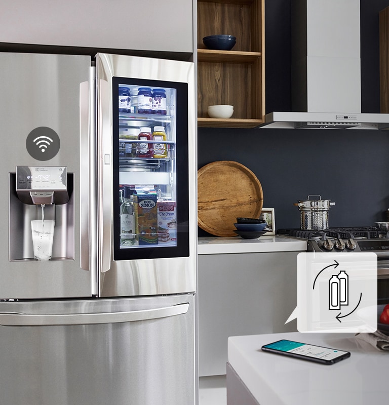 Ikona odtwarzania/wstrzymania na dole ekranu nad trzema kropkami. Druga kropka jest wyróżniona na znak, że to jest drugi z trzech filmów w karuzeli. Film zaczyna się od sceny ukazującej lodówkę LG w kuchni. Z drzwi urządzenia zaczyna płynąć woda, która trafia do szklanki. Woda przestaje płynąć i nad dozownikiem pojawia się ikona Wi-Fi. Nad telefonem leżącym na blacie pojawia się ikona. Przedstawia ona dwie butelki i strzałki tworzące okrąg sygnalizujące konieczność wymiany materiałów eksploatacyjnych.