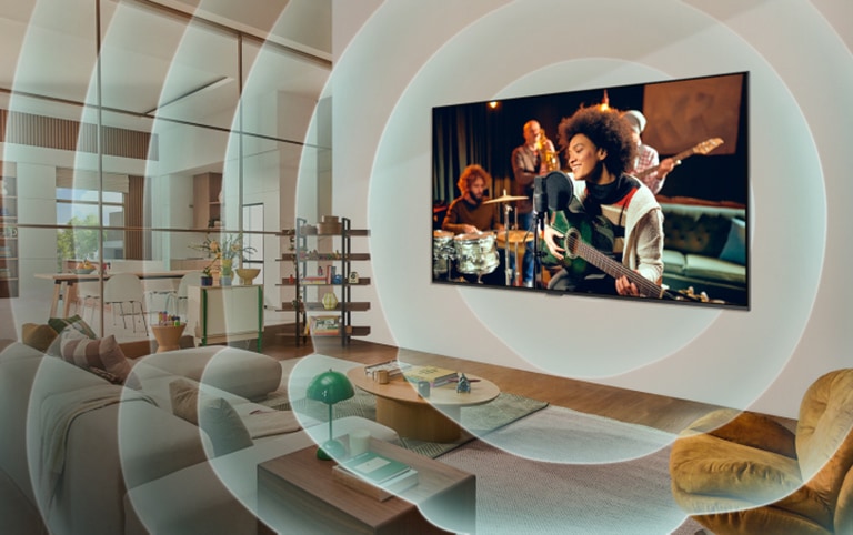 LG TV zamontowany na ścianie w salonie, z gitarzystą na ekranie. Grafika koncentrycznych okręgów reprezentujących fale dźwiękowe.