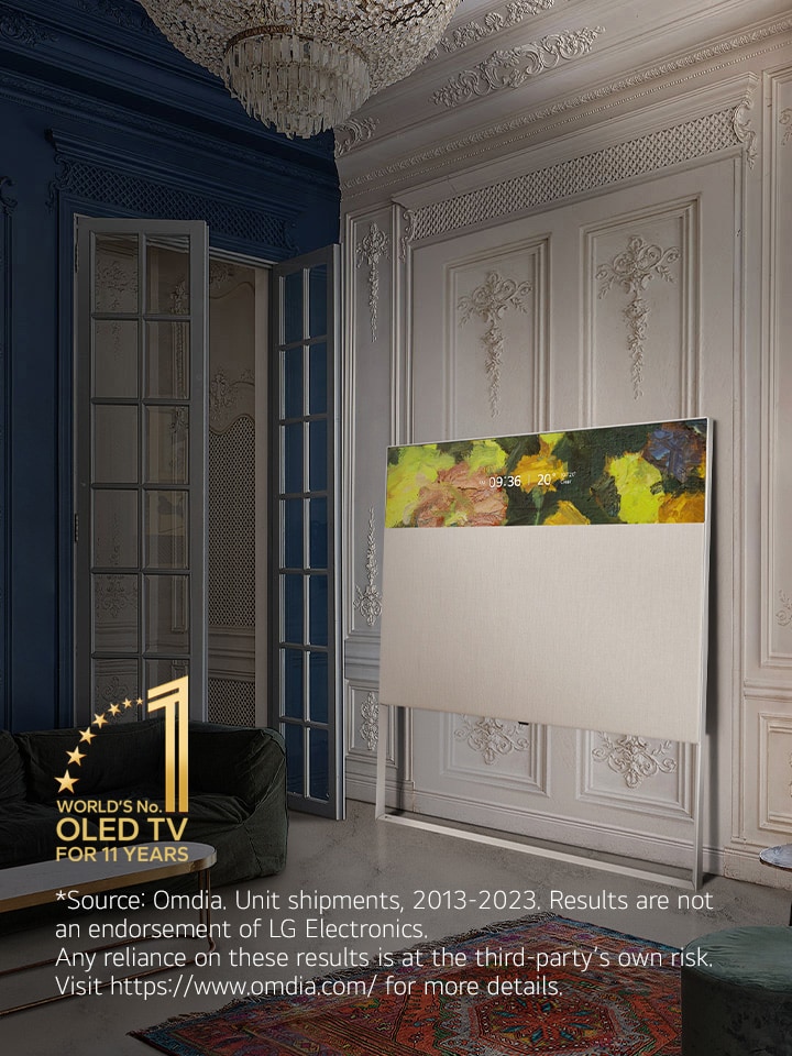 EASEL w widoku liniowym oparty o zdobioną ścianę. Stoi obok obrazu na ścianie i za dywanem o misternym wzorze. Emblemat „10 Year World's No.1 OLED TV”.	