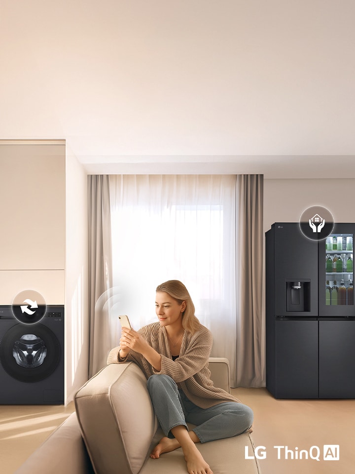 Kobieta na sofie używająca telefonu do sterowania pralką i lodówką LG w jasnym salonie