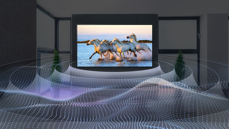 Cztery białe konie biegnące w wodzie na ekranie telewizora z grafiką dźwięku przestrzennego.