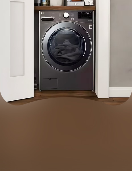 Vista frontale della lavatrice LG installata in uno spazio tipo ripostiglio con ante aperte e biancheria all’interno del cestello