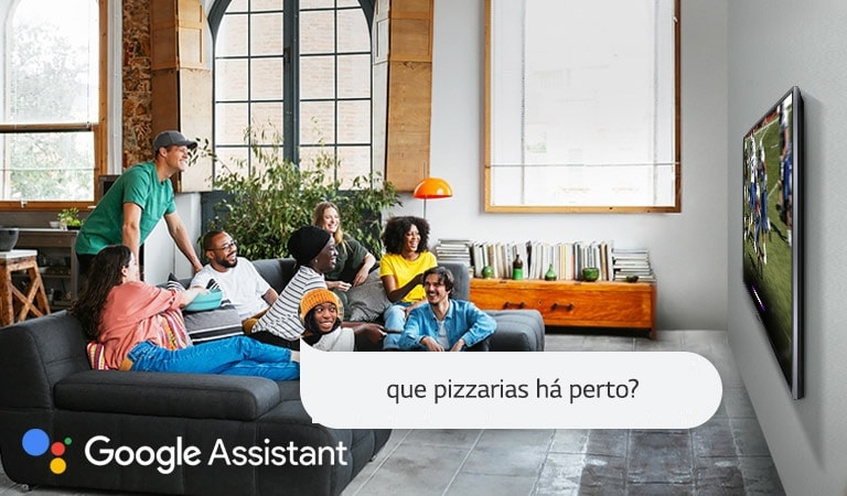 Mulher a ver jogo de futebol americano na televisão e a perguntar ao Google Assistant se há pizzarias perto