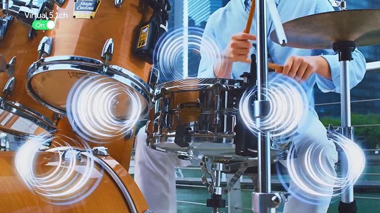 Conforme um homem toca bateria, os efeitos sonoros são simulados na bateria.