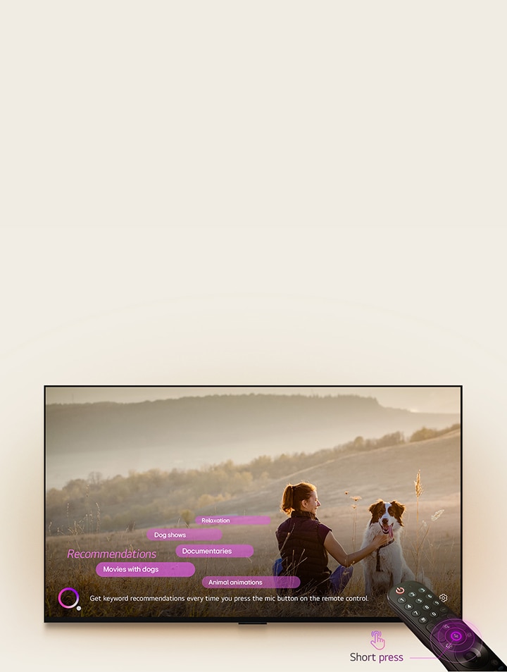 Uma LG TV apresenta uma imagem de uma mulher e um cão, num campo vasto. Na parte inferior do ecrã é apresentado o texto " Receba recomedações de keywords cada vez que premir no botão de microfone, no comando.", junto ao círculo roxo central, num vídeo ilustrativo. Barras em cor rosa apresentam as seguintes palavras-chave como recomendações: Programas de cães, Animações de Animais, Documentários, Filmes com Cães e Relaxamento. Em frente à LG TV, o LG Magic Remote é apontado para a televisão com círculos néon roxos ao redor do botão do microfone.  Junto ao comando, é apresentado um vídeo ilustrativo de um dedo a pressionar um botão e a surgir o texto "Pressionar Brevemente".