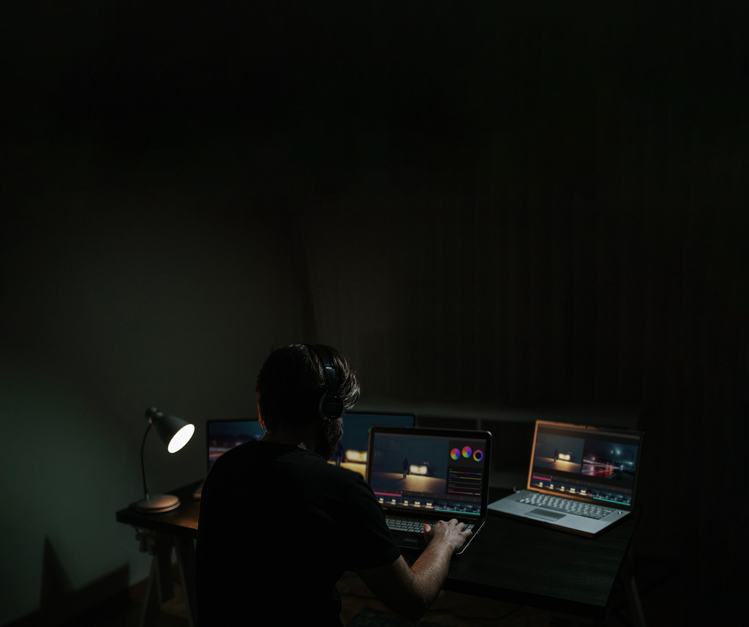 Um homem edita um filme enquanto observa o software em um monitor de computador