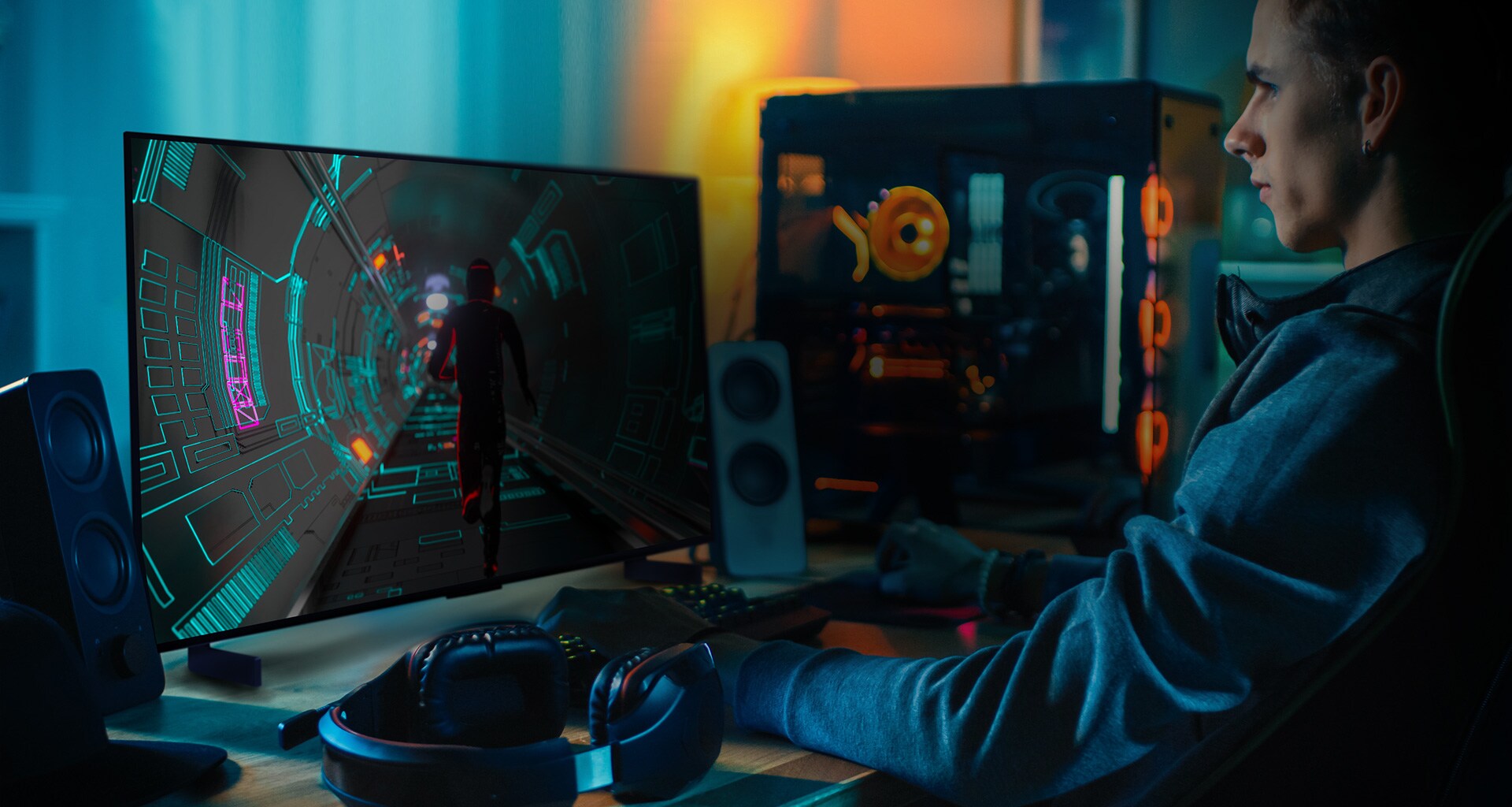A person plays a sci-fi game at his personal desk on a small LG OLED television