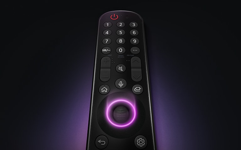 يظهر جهاز التحكم عن بُعد LG Magic Remote مع الزر الدائري الأوسط، حيث ينبعث ضوء أرجواني نيون حول الأزرار لإبرازها. توهج أرجواني ناعم يحيط بجهاز التحكم عن بُعد على خلفية سوداء.