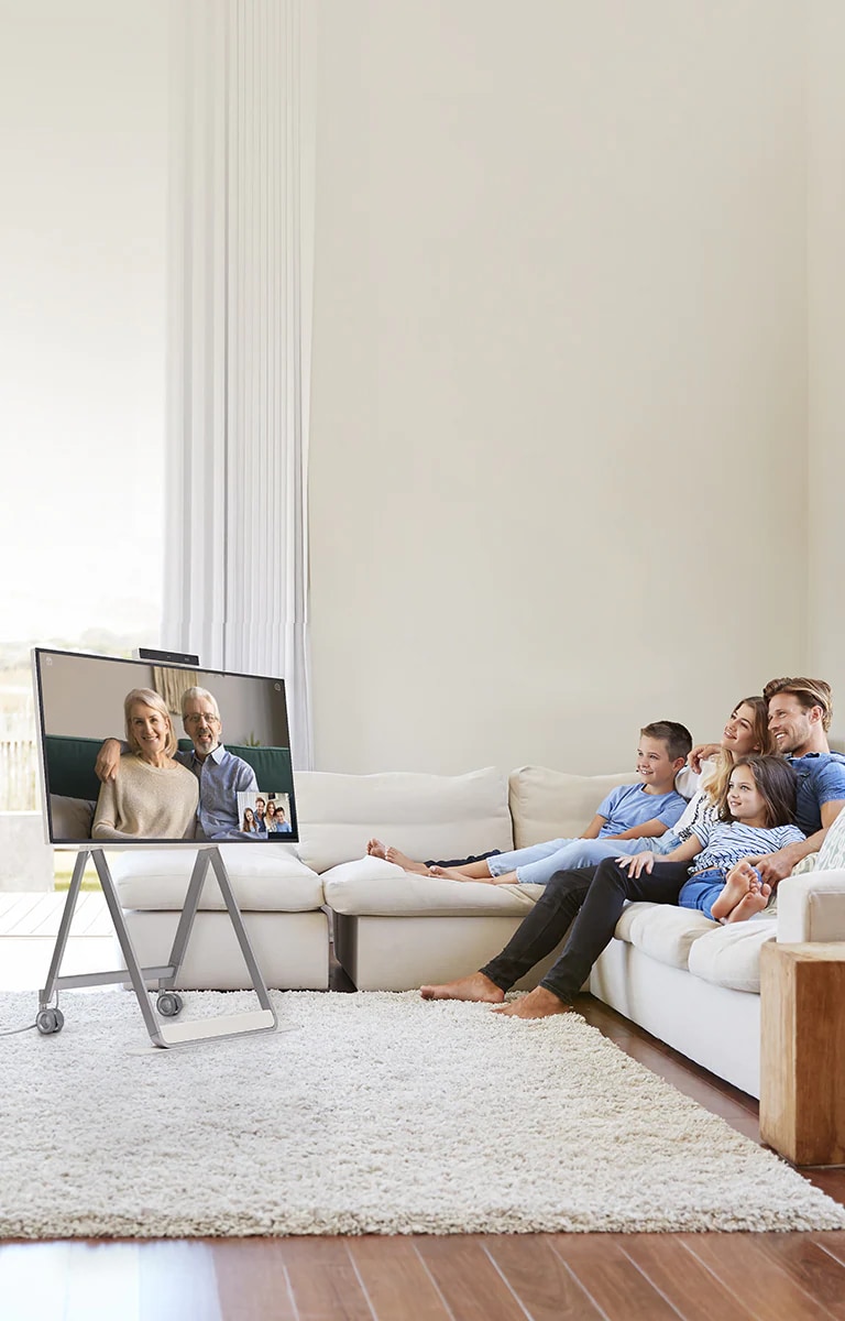 تقوم عائلة بإجراء مكالمة فيديو باستخدام الجهاز الموجود في غرفة المعيشة