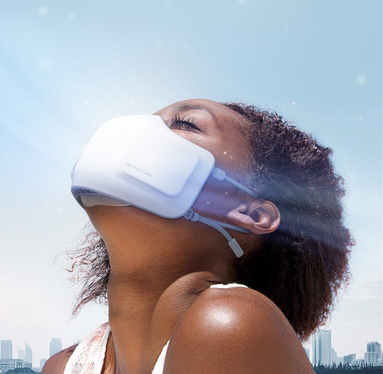 A girl tilts her head back wearing the PuriCare Wearable Air Purifier seen from the side. There is a cityscape in the background and wind with fine dust blowing by.