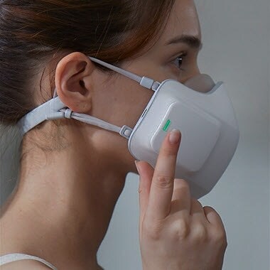 The side view of the wearable air purifier on a woman. Her finger is tapping to turn it on.