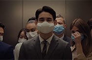 A video opens with a crowded elevator. The man in front is wearing the PuriCare Wearable Air Purifier while everyone else is wearing normal cloth masks except one person. The person not wearing a mask coughs and everyone else in the elevator moves uneasily while the man with the PuriCare mask stands confidently and a script comes into the center reading &quot;Air doesn't always have to be shared&quot;. The camera moves in to zoom in on the mask and then goes into the filter and shows a magnified focus on the inner workings of the mask. The bottom reads &quot;The PuriCare Filter blocks out dust, viruses, bacteria and allergens&quot;. The focus goes through to the person's mouth and shows a mouth breathing comfortably and then back out through the filter to see the crowded elevator again. Next a white background and then the words &quot;Technology that lets you breath easy&quot;. Finally the words disappear and the LG PuriCare Wearable Air Purifier logo ends the video.