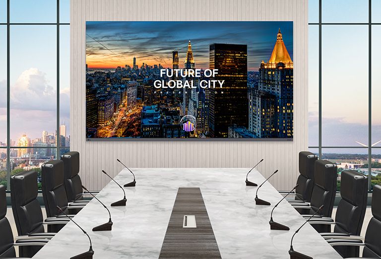 In a luxurious meeting room with a wide conference table and a view of the scenery outside, there is a LG MAGNIT All-in-One, LAAA series, installed on the wall. The 136-inch LAAA screen vividly displays presentation materials for the meeting.