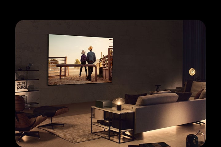 En cowboyfilm visas på en väggmonterad LG OLED-TV i ett mysigt vardagsrum på kvällen. Det syns inga kablar runt smart-TV:n. Wireless Connect Box sitter snyggt på ett sidobord. Bilden glider ut för att visa ett annat vardagsrum med en pittoresk scen av en bil på en motorväg på LG OLED TV-skärmen. Smart-TV:n står på ett golvstativ och det syns inga kablar runt den. Dess Wireless Connect Box sitter snyggt på ett sidobord.