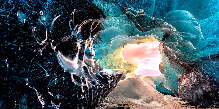 Perspektiv från insidan av en grotta, med utsikt mot ingången. Grottan har ett overkligt utseende med mycket detaljerade sten- och kristallformationer. Scenen framhäver den visuellt förlustfria bildkvaliteten på LG True Wireless TV.