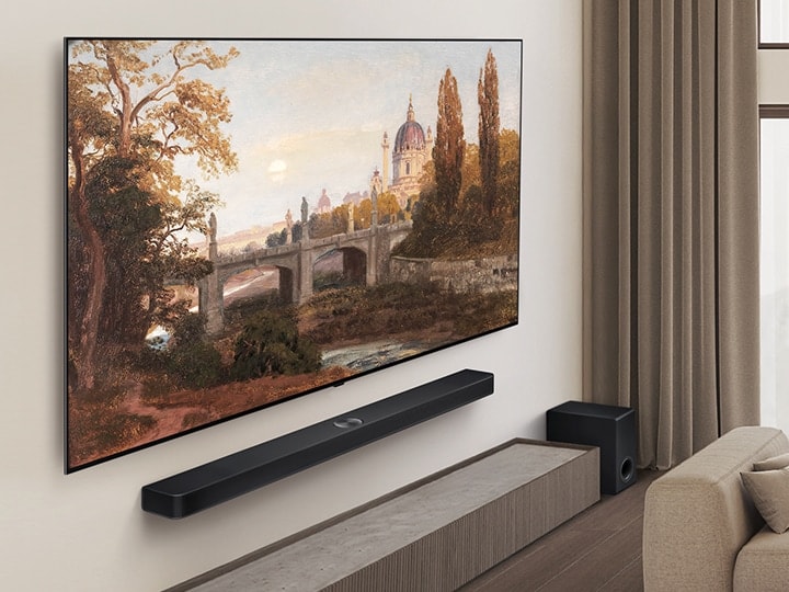 Vardagsrum med en LG OLED TV och LG Soundbar som är väggmonterade. Perspektivet är från en vinkel för att visa TV:ns smala ram mot väggen.