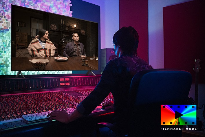 En regissör som redigerar filmen "Killers of the Flower Moon" framför en kontrollpanel på en LG QNED TV. Längst ner till vänster, Dolby Vision-logotypen och FILMMAKER MODE-logotypen.