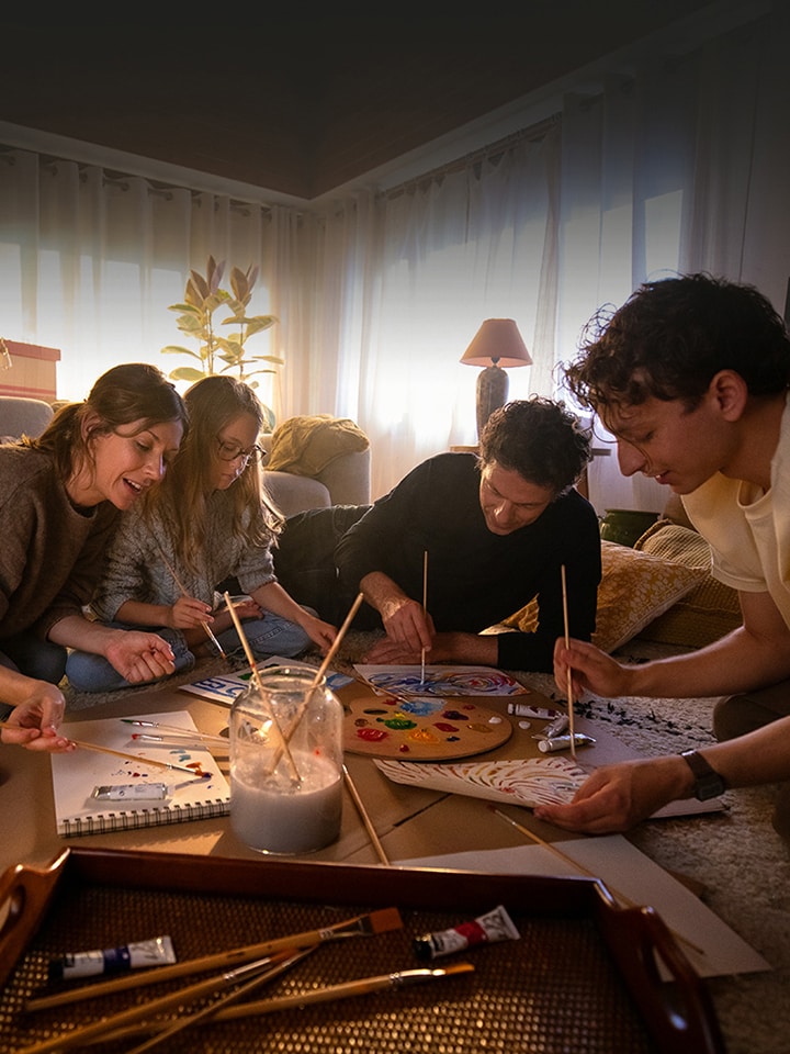 Familjen samlas på den mysiga vardagsrumsmattan och ritar bilder i ett varmt hus.	
