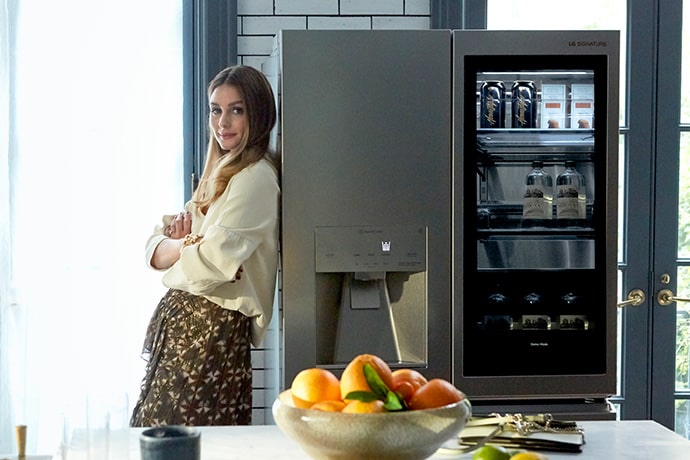Olivia Palermo leans against the LG SIGNATURE Refrigerator.